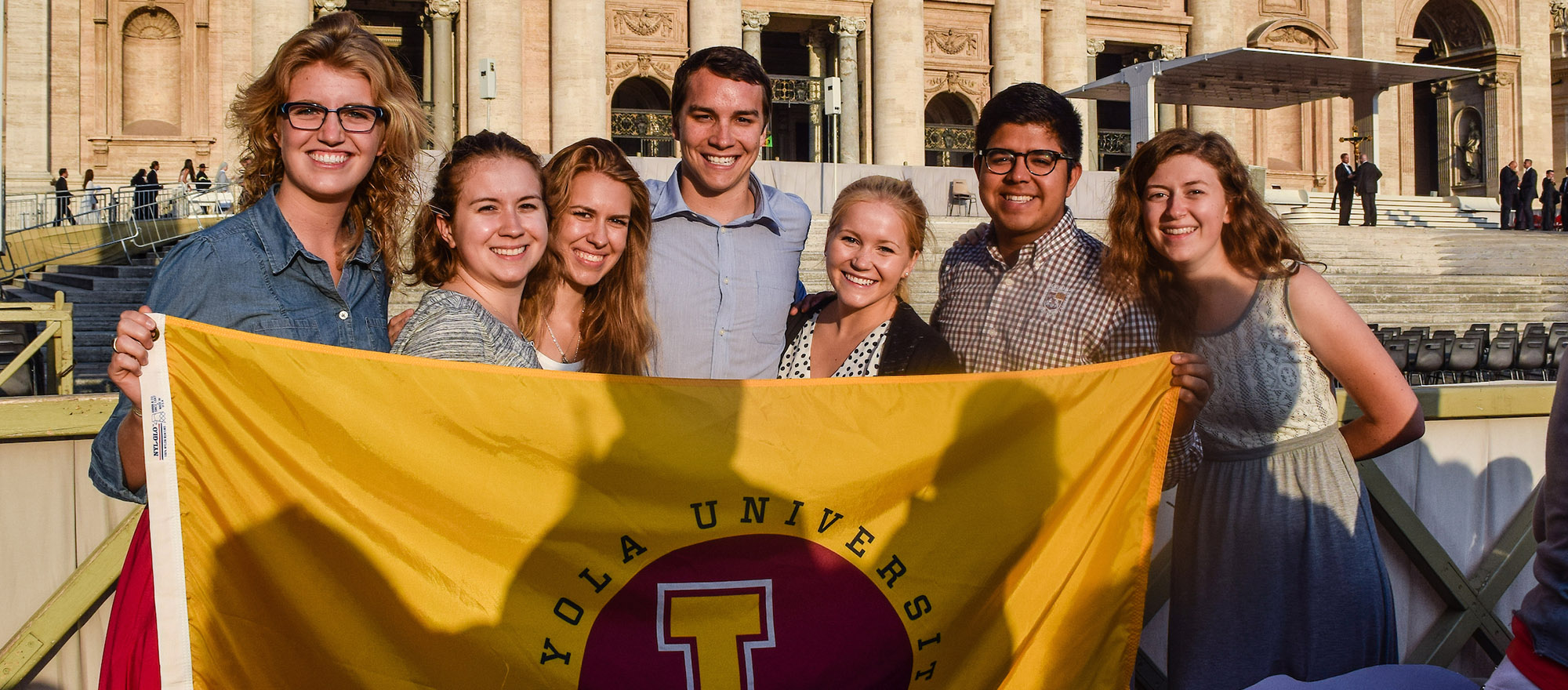 2021 JFRC Students Holding Loyola Flag Rome 2000x880 MQ.jpg